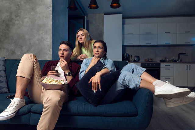 Friends enjoying a movie night on the couch with popcorn