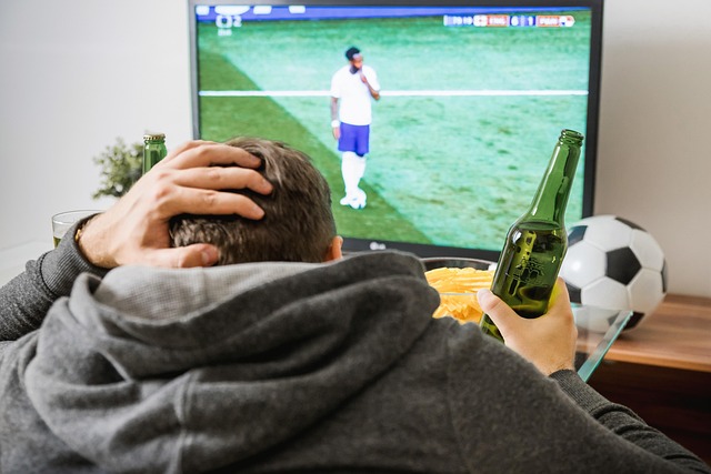Fan celebrating while watching live football on TV